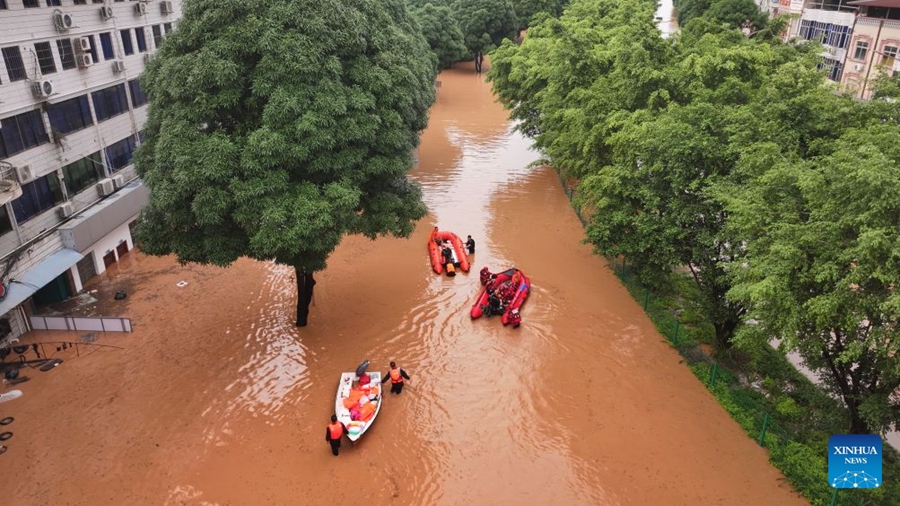 Soccorritori evacuano i residenti rimasti bloccati a seguito delle forti piogge nel Guangxi