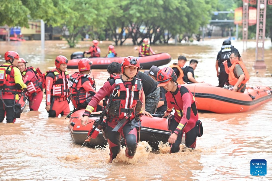 Soccorritori evacuano i residenti rimasti bloccati a seguito delle forti piogge nel Guangxi