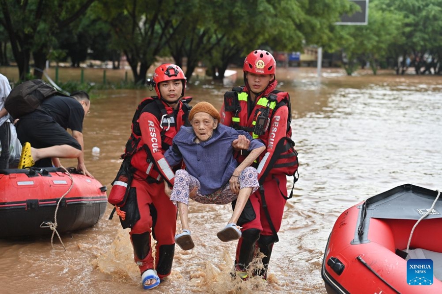 Soccorritori evacuano i residenti rimasti bloccati a seguito delle forti piogge nel Guangxi