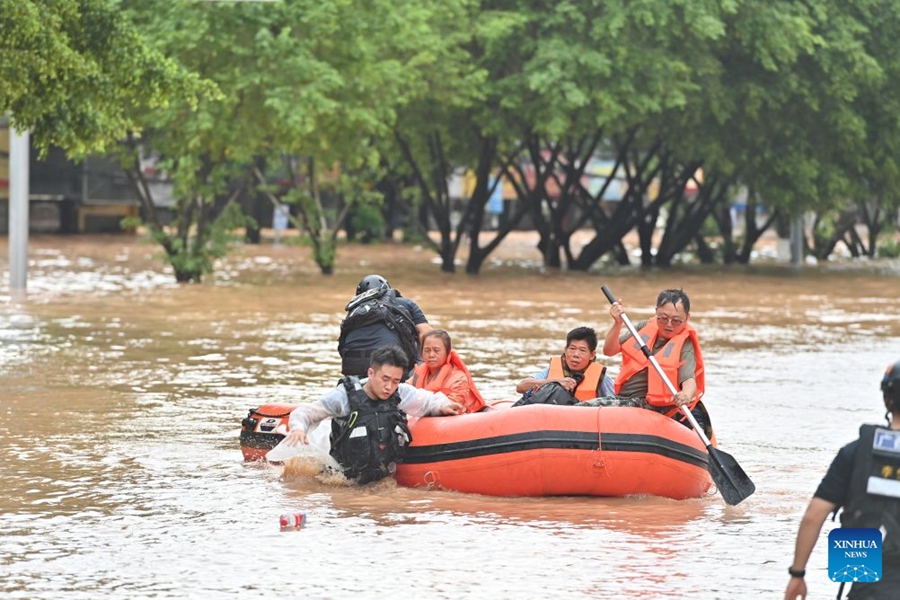 Soccorritori evacuano i residenti rimasti bloccati a seguito delle forti piogge nel Guangxi