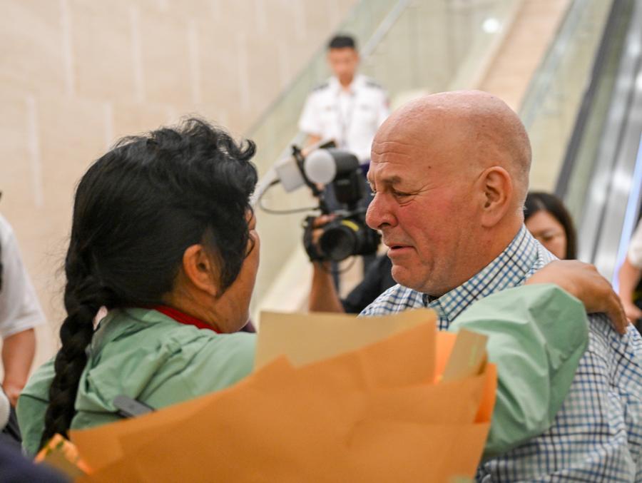 Yin Yuzhen riabbraccia Ronald Sakolsky all'aeroporto di Ordos, nella Regione Autonoma della Mongolia Interna, Cina settentrionale. (23 agosto 2026 - Xinhua/Lian Zhen)