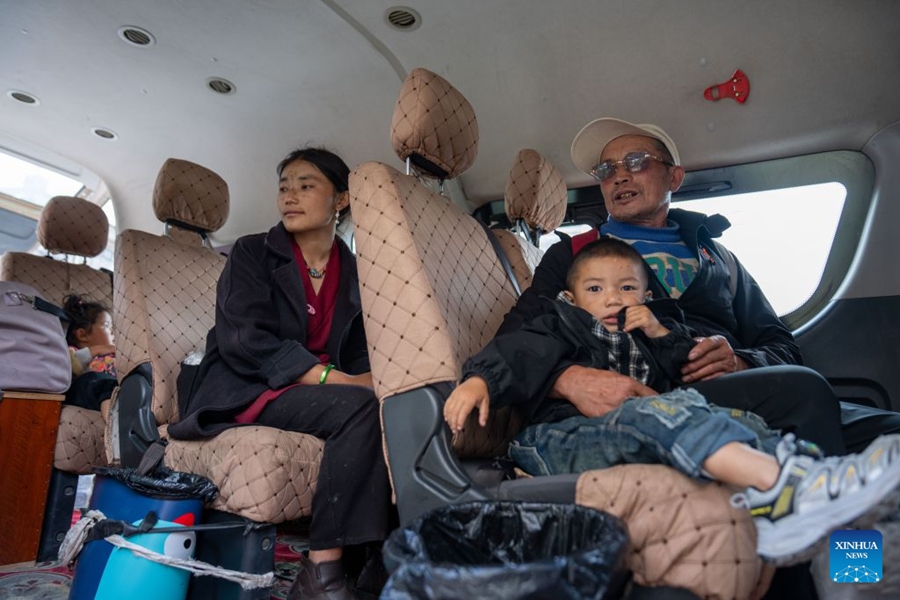 Persone nella zona colpita dalla colata di fango ritornano a casa a Gyirong, nello Xizang