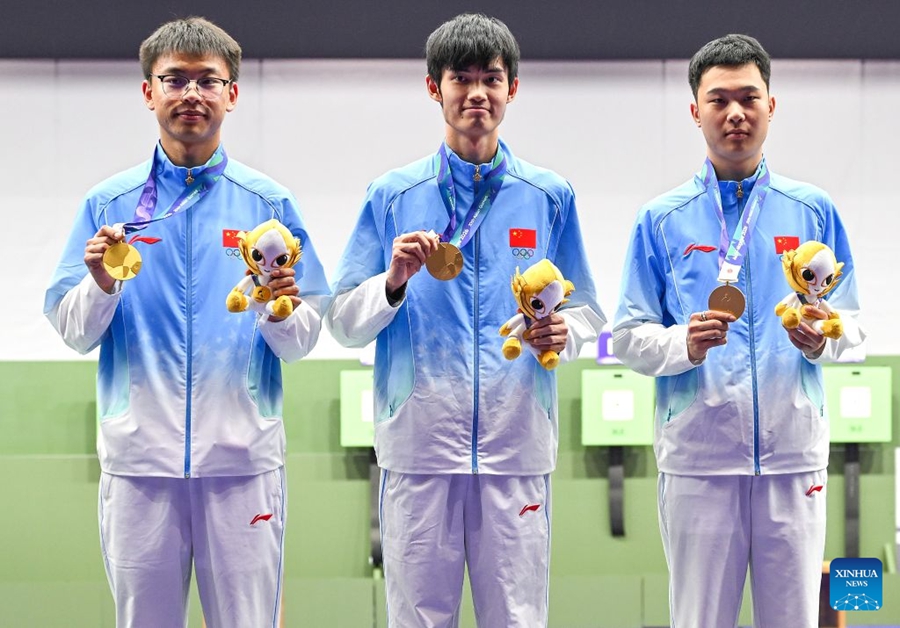 Atleti cinesi vincitori della medaglia d'oro Ma Sihan, Sheng Lihao e Zhang Changhong (da destra a sinistra) posano durante la cerimonia di premiazione della gara a squadre maschile di carabina ad aria compressa da 10 metri ai XX Giochi Asiatici di Aichi-Nagoya 2026, a Toyota, nella prefettura di Aichi, Giappone. (21 settembre 2026 - Xinhua/Liu Lei)