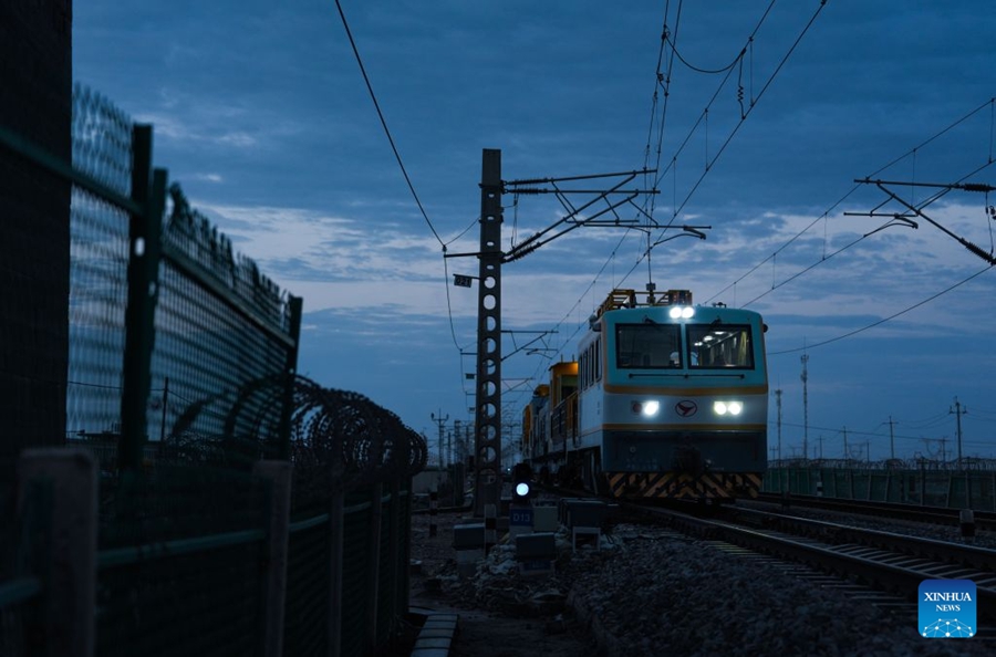 Operai puliscono gli isolatori della linea di contatto lungo la ferrovia Qinghai-Xizang