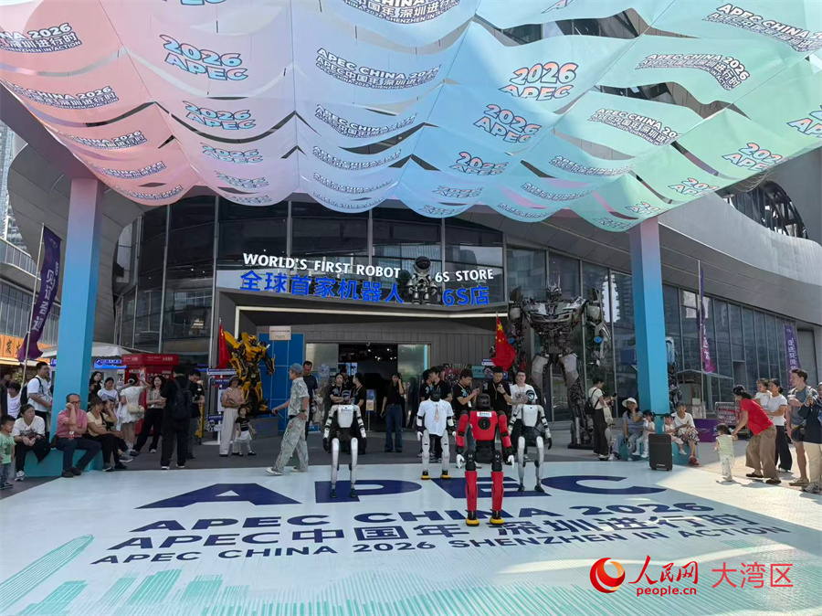 Visitatori osservano un'esibizione di robot all'esterno del primo negozio al mondo "6S" dedicato ai robot, situato nel distretto Longgang di Shenzhen. (21 ottobre 2026 - Yang Qian/Quotidiano del Popolo Online)